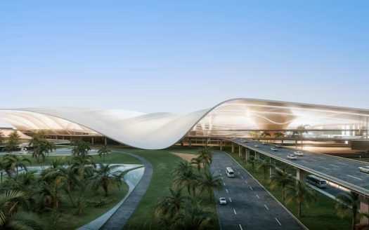 Une image d’un terminal d’aéroport moderne et futuriste avec un toit élégant en forme de vague. Il est entouré de palmiers luxuriants avec des voitures sur une route voisine sous un ciel clair au crépuscule, à proximité de projets immobiliers importants à Dubaï.