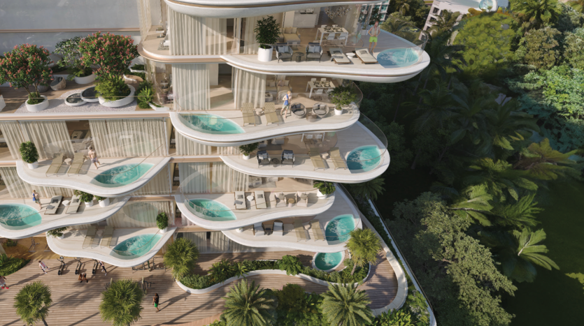 Un bâtiment moderne de plusieurs étages avec des balcons incurvés, chacun doté de piscines privées, fait partie du superbe projet Beach Walk Imtiaz. Les balcons sont ornés de mobilier d'extérieur et de verdure, donnant sur une végétation tropicale luxuriante et les jardins en contrebas. Le design est élégant et luxueux, se fondant dans l'environnement naturel.