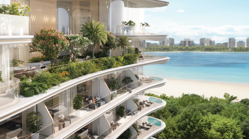 Cette luxueuse résidence à plusieurs niveaux de l'immobilier de Dubaï surplombe une plage immaculée et l'océan. Le bâtiment dispose de vastes balcons luxuriants avec une verdure et des arbres abondants. De grandes fenêtres offrent une vue panoramique et les toits de la ville lointaine sont visibles sous un ciel bleu clair.