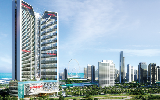 Deux grands gratte-ciel portant la marque « DAMACURE » dominent l&#039;horizon d&#039;une ville moderne avec une verdure luxuriante, une grande roue et un océan bleu clair en arrière-plan, mettant en valeur le premier immobilier de Dubaï.