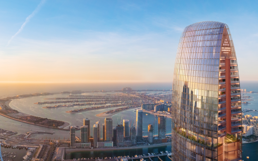 Vue aérienne d'une ville moderne au lever du soleil, avec un gratte-ciel incurvé au premier plan surplombant une zone côtière avec une série d'îles artificielles près de Dubaï.