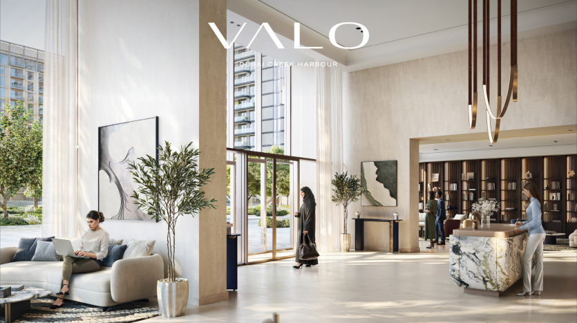 Hall d'entrée élégant avec mobilier moderne, jardins verticaux et suspensions élégantes. Deux personnes se tiennent près de l’entrée tandis qu’une autre est assise avec un ordinateur portable. Logo "YALO Piraeus Harbour" transformé en logo de l'agence immobilière Dubaï en haut.