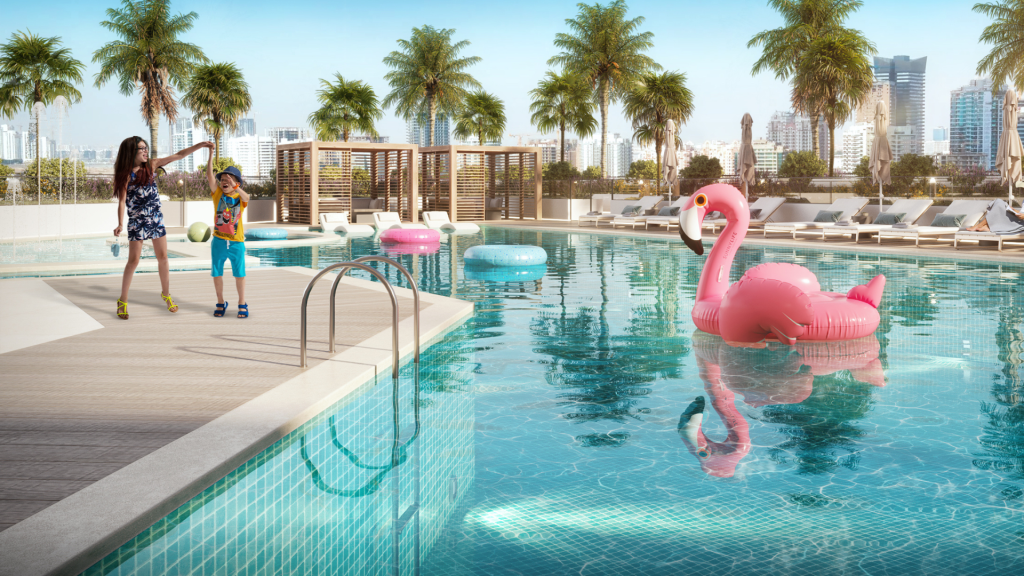 Une mère et son enfant interagissent de manière ludique au bord d'une piscine ensoleillée sur le toit avec un grand flamant rose flottant à Dubaï. Paysage urbain moderne en arrière-plan avec un ciel clair.