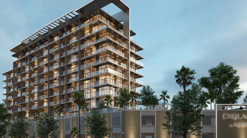 Un appartement moderne de grande hauteur à Dubaï avec des balcons éclairés au crépuscule. Des palmiers encadrent l&#039;extérieur du bâtiment tandis qu&#039;un panneau indiquant « ENQLAVA » est affiché à l&#039;avant.