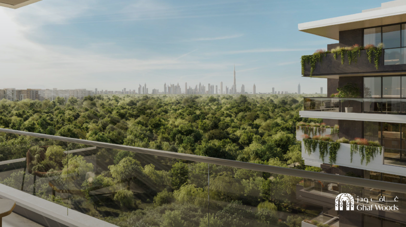 Vue en plongée depuis un balcon donnant sur une vaste forêt verte et sur les toits d'une ville lointaine avec des immeubles de grande hauteur, dont une tour proéminente. Le balcon comporte des balustrades en verre et un bâtiment moderne voisin avec de la verdure en cascade depuis ses balcons. Un logo « Ghaf Woods » se trouve dans le coin inférieur droit.