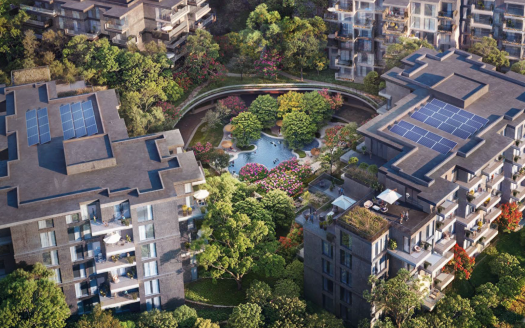 Vue aérienne d'un complexe résidentiel luxueux comprenant plusieurs immeubles d'appartements modernes, dotés de panneaux solaires sur les toits. Le complexe est entouré d'une verdure luxuriante, d'arbres et de jardins paysagers nichés dans les bois sereins de Ghaf, comprenant un plan d'eau central avec des plantes à fleurs vibrantes.