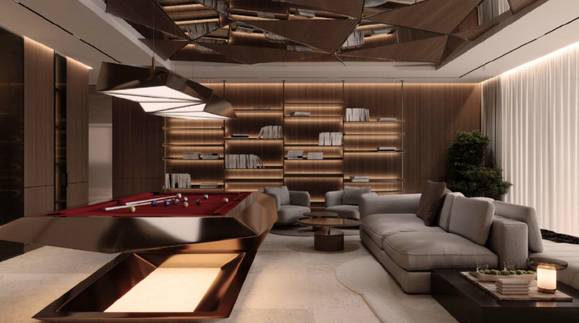 Un salon moderne dans une luxueuse villa à Dubaï comprend une élégante table de billard en feutre rouge surmontée d'un luminaire géométrique. La pièce dispose de sièges gris confortables, d'un mur avec des étagères éclairées et d'une grande plante. Le design contemporain comprend des boiseries et un plafond réfléchissant.