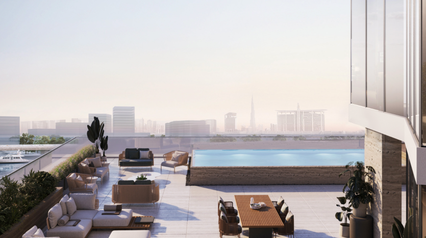 L'élégant toit-terrasse de l'Azura Residences est doté d'un mobilier moderne, notamment de chaises longues, de canapés et d'une table à manger en bois. Une élégante piscine rectangulaire offre une vue sur les toits de la ville avec des immeubles de grande hauteur et une haute tour en arrière-plan. Le ciel est clair et lumineux.