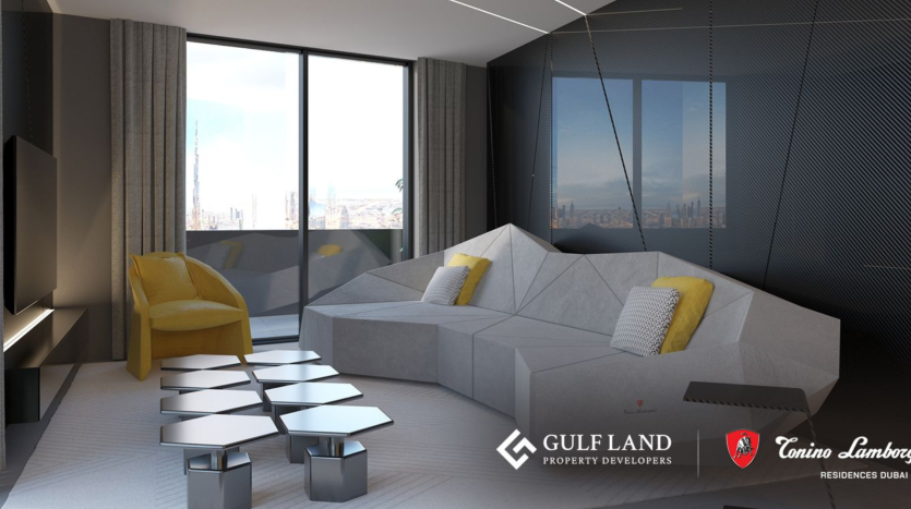Un salon moderne avec un canapé géométrique gris, une chaise jaune et des tables d'appoint hexagonales métalliques. De grandes fenêtres offrent une vue sur la ville. Les logos de Gulf Land Property Developers et de Tonino Lamborghini Residences Dubai se trouvent dans le coin inférieur droit.