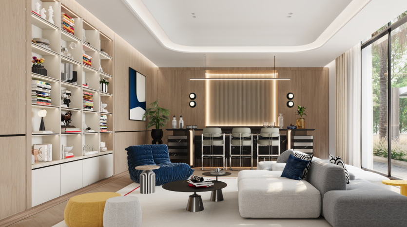 Un salon moderne de la Villa Karl Lagerfeld avec une grande étagère, de confortables canapés bleus et gris et un coin repas en arrière-plan. Décor contemporain avec grandes fenêtres et accents de bois.