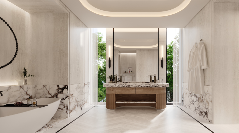 Une luxueuse salle de bains moderne de la Villa Karl Lagerfeld avec des murs et un comptoir en marbre, une vanité en bois, un grand miroir et un éclairage d&#039;ambiance zénithal. Une baignoire et de la verdure sont visibles sur le côté.