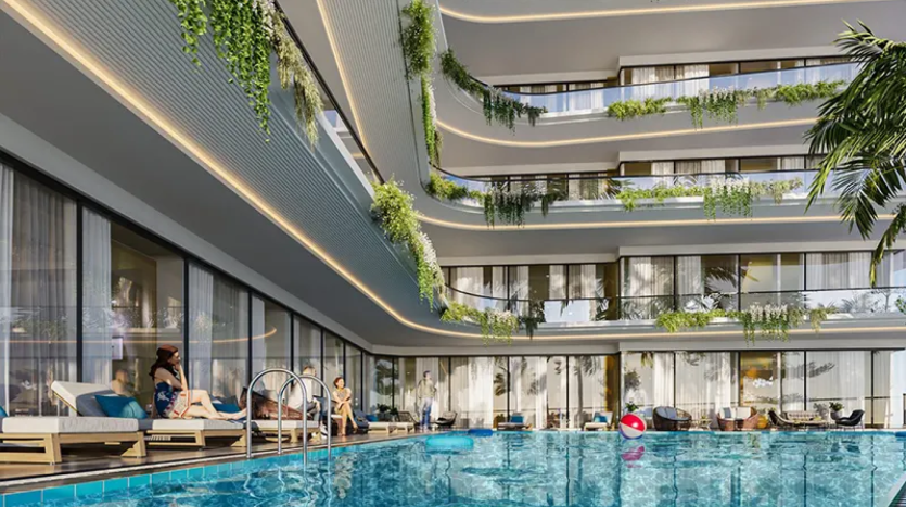 Cour d'hôtel moderne avec une grande piscine, des balcons à plusieurs étages ornés de plantes et des clients se relaxant sur des chaises longues au bord de la piscine. Des jouets flottants se trouvent dans la piscine, notamment un ballon de plage gonflable. Un éclairage chaleureux met en valeur le design contemporain.