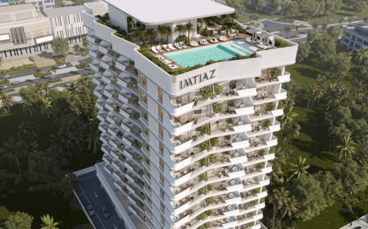 Vue aérienne d'un immeuble résidentiel moderne de plusieurs étages nommé « IMTIAZ », doté de balcons privés et d'une piscine sur le toit avec des chaises longues. Ce superbe morceau de l'immobilier de Dubaï est entouré d'une verdure luxuriante et de structures voisines, avec une route visible en arrière-plan.