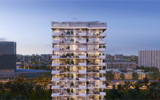 Un immeuble moderne de grande hauteur nommé « IMTIAZ » se dresse bien en évidence sur un paysage urbain crépusculaire. Le bâtiment comporte plusieurs étages avec de grands balcons en verre ornés de plantes. Les bâtiments de la ville environnante et la verdure sont visibles en arrière-plan.