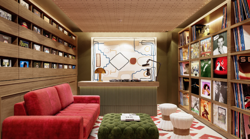 Une chambre confortable et moderne du Hyde Residences comprend un canapé rouge, un pouf capitonné vert et deux tabourets blancs. Les murs sont bordés d’étagères contenant des disques vinyles et d’autres objets. Un plateau tournant est posé sur une console sous une œuvre d’art abstraite, éclairée par un éclairage chaleureux.