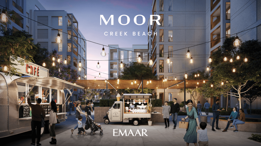 Une soirée animée à MOOR Creek Beach, où les gens marchent, discutent et dînent à proximité de food trucks illuminés et d'arbres ornés de suspensions. Des immeubles d'appartements modernes encadrent la zone et l'habitat de zone humide à proximité ajoute une touche de beauté naturelle. Le texte indique « MOOR Creek Beach EMAAR.