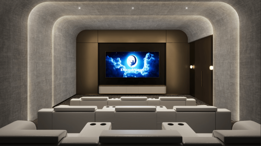 Un home cinéma moderne au One Residences avec un grand écran affichant le logo DreamWorks. L'espace comprend des murs incurvés avec un éclairage tamisé, plusieurs sièges inclinables blancs moelleux disposés en rangées et des éléments de design élégants et contemporains.