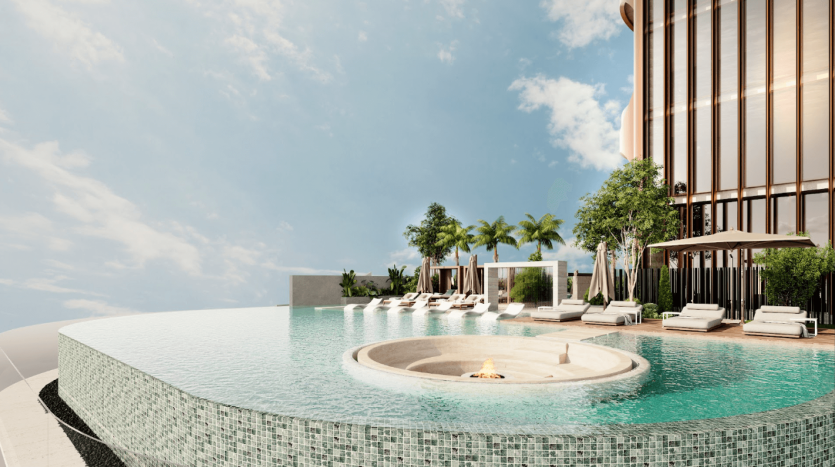 Une piscine à débordement avec un petit foyer au centre est entourée de chaises longues et de parasols. Les palmiers et les arbustes verts ajoutent une touche tropicale, tandis que le bâtiment moderne de One Residences avec de hautes fenêtres et des détails architecturaux se dresse à proximité sous un ciel bleu clair.