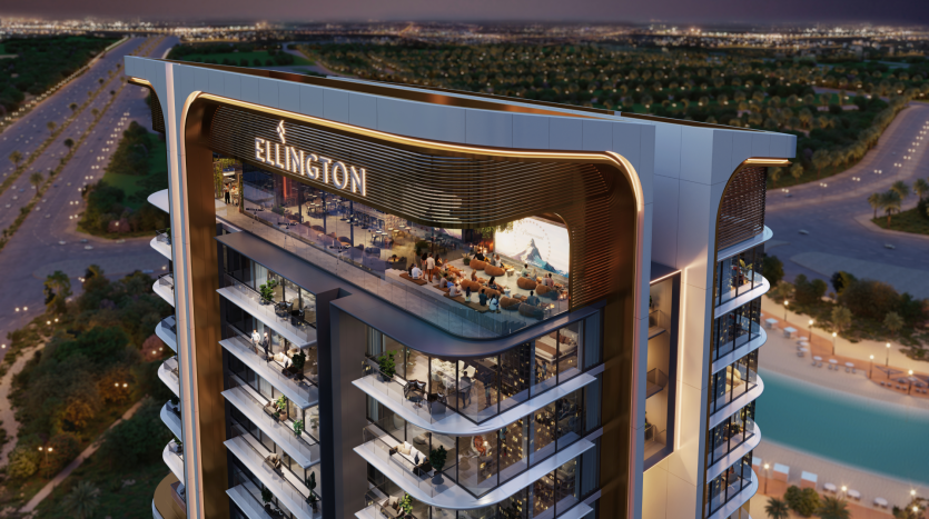 Belgrove Residences, a modern high-rise designed by Ellington, is illuminated at night. The top floor features an open terrace with seating area, overlooking a cityscape of palm-lined streets and distant lights. The building features elegant architectural design and numerous balconies.