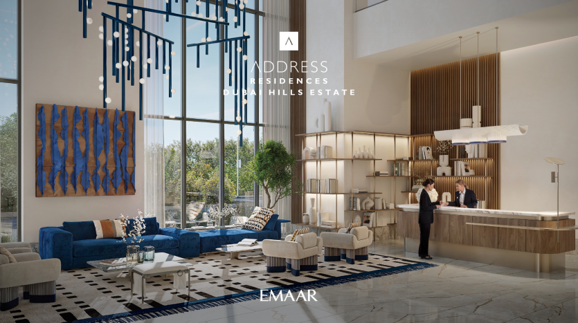 The lobby of Address Residences Dubai Hills is spacious and modern. It features large windows, a blue and beige color palette, a blue abstract artwork on the wall and elegant furnishings. There is a reception desk where a member of staff assists guests.