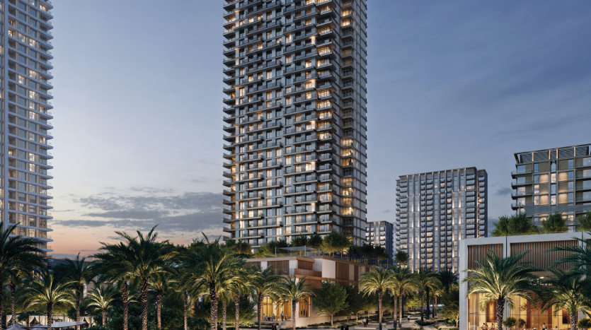 Des immeubles de grande hauteur, comme Address Residences, illuminés au crépuscule, entourés de palmiers et de verdure. Le ciel passe du coucher du soleil au soir, avec des nuages épars. La scène capture un quartier résidentiel urbain avec une architecture moderne et une atmosphère sereine.