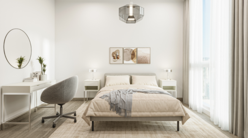 Une chambre moderne et minimaliste avec un lit bien fait avec des draps beige clair, situé entre deux tables de nuit blanches avec des lampes. Un bureau avec un miroir rond, de petites plantes en pot et une chaise pivotante grise se trouve sur la gauche. La pièce est lumineuse et baignée de lumière naturelle, offrant une élégance du milieu du siècle.