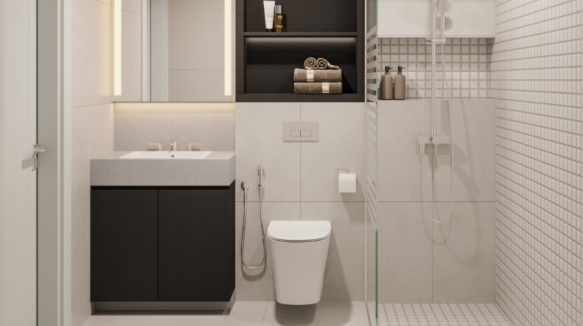 Une salle de bains moderne avec un meuble vasque à gauche, avec un plan de travail gris et un meuble noir. Les toilettes sont au centre, avec un bidet et un porte-papier hygiénique. À droite se trouve un espace douche vitré avec carrelage blanc et étagère à shampoing, mêlant un design intemporel au style de ce siècle.