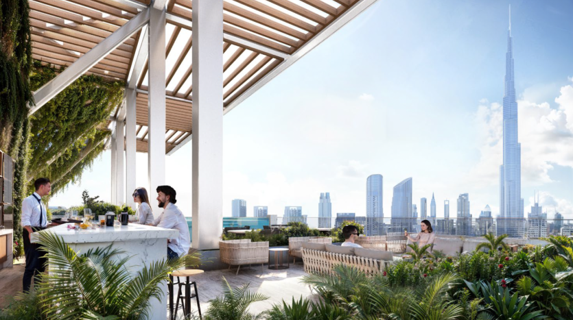 Une terrasse sur le toit des résidences Fairmont avec des gens assis et socialisant. La terrasse est ornée de plantes et dispose d'un coin bar. L'horizon de la ville, y compris un grand gratte-ciel, est visible en arrière-plan sous un ciel clair et ensoleillé.