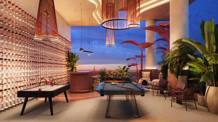 An elegant leisure room at Allura Residences with modern sunset decor. It features a pool table, air field hockey table, high-end seating and a wall installation with round elements. Large plants and unique ceiling lights enhance the ambience. A breathtaking view is visible from outside.