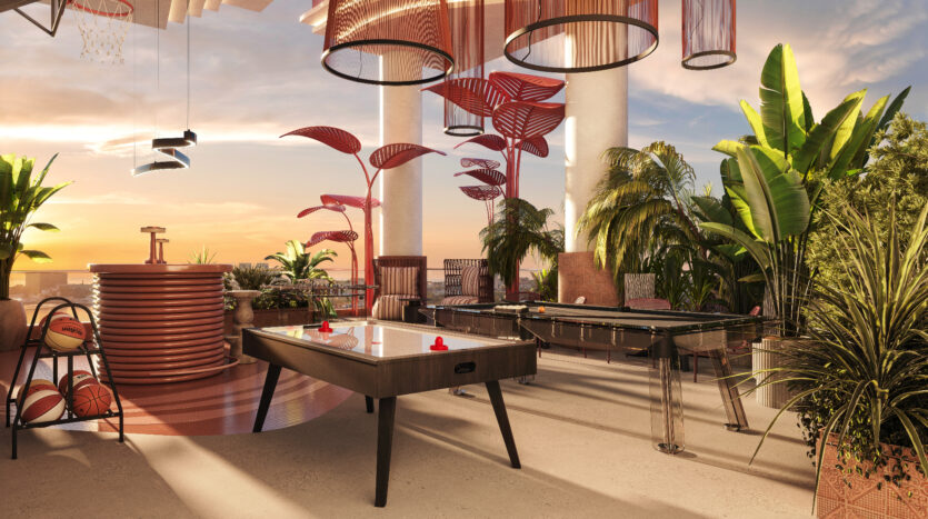 Allura Residences' modern recreation area includes an air field hockey table, foosball table and basketball hoop. The space features vibrant plant decorations, elegant pendant lighting and sunset views in the background, creating a relaxing and fun atmosphere.