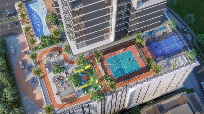 Vue aérienne du toit de l'immeuble Elysée 3, avec piscine, terrain de basket, aire de jeux et court de tennis. L'espace est agrémenté de palmiers et de sièges de loisirs, offrant un espace de loisirs au milieu d'un environnement urbain.