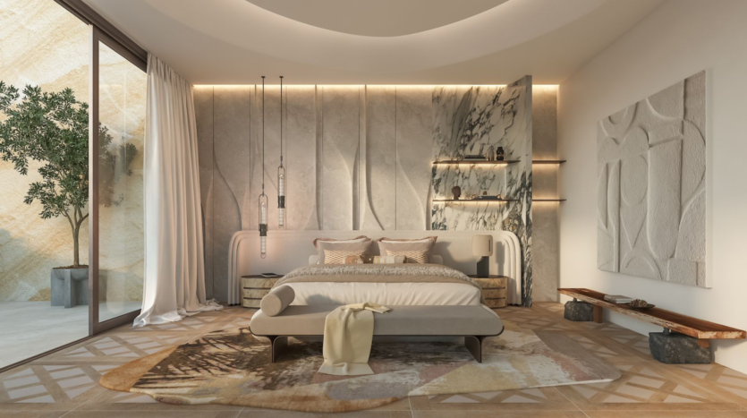 Une chambre moderne et minimaliste avec un grand lit centré contre un mur texturé. La pièce dispose d'une porte vitrée allant du sol au plafond avec des rideaux transparents, permettant à la lumière naturelle de pénétrer à l'intérieur. La décoration comprend des luminaires suspendus au plafond, un tapis à motifs et un arbre dans le coin.