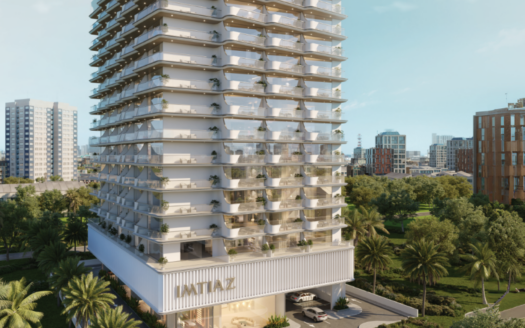 Un moderno edificio de gran altura con un diseño elegante y balcones panorámicos. El letrero reza &quot;IMTIAZ&quot;. Rodeado de exuberante vegetación, al fondo se ve el perfil de la ciudad bajo un cielo azul despejado.