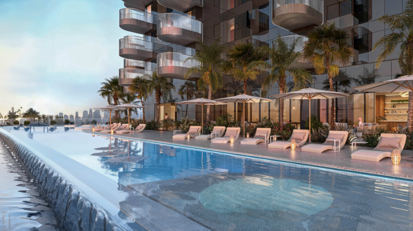 Une luxueuse piscine à débordement avec chaises longues et parasols complète le chic W Residences, niché dans les Jumeirah Lake Towers. Le quartier est orné de palmiers et le bâtiment en verre reflète un ciel bleu clair.