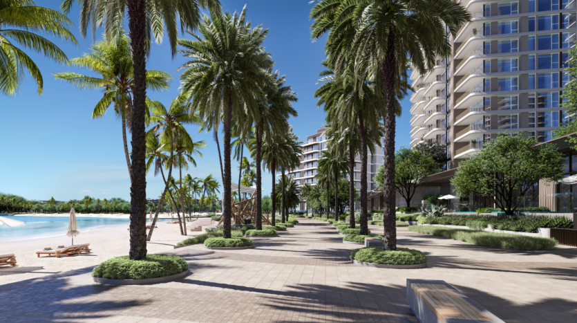 Une promenade de plage tropicale bordée de palmiers par une journée ensoleillée, avec des chaises longues, des parasols et des immeubles modernes de grande hauteur en arrière-plan. La promenade est pavée et aménagée avec une végétation luxuriante, offrant une atmosphère sereine au bord de l'océan.