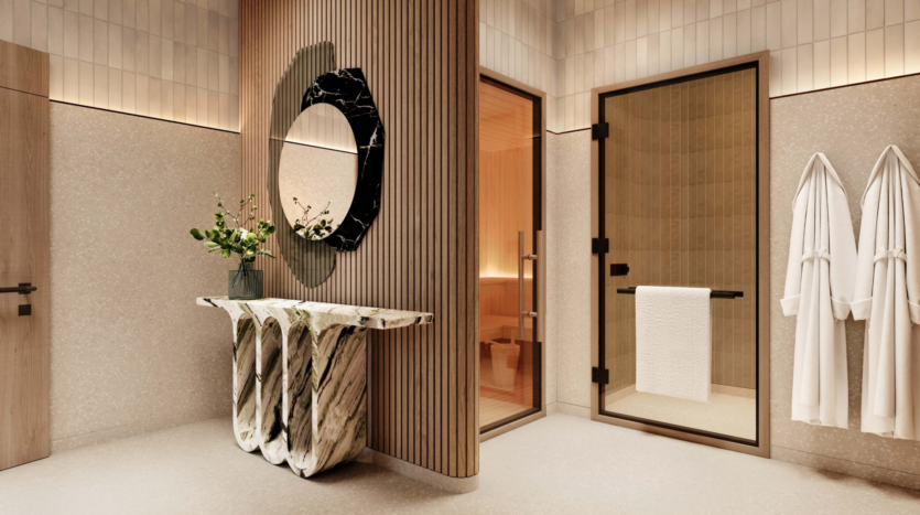 Salle de bains luxueuse au design moderne au W Residences. Un lavabo en marbre unique est associé à un grand miroir artistique. Une porte vitrée mène à un sauna et deux peignoirs blancs sont accrochés au mur. L'espace, inspiré des Jumeirah Lake Towers, est élégamment éclairé et doté de boiseries claires.