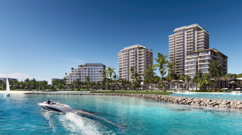 Une station balnéaire avec plusieurs immeubles modernes de grande hauteur entourés de palmiers et d'une végétation luxuriante. Un hors-bord de luxe navigue dans l'eau turquoise au premier plan, avec un ciel bleu clair au-dessus.