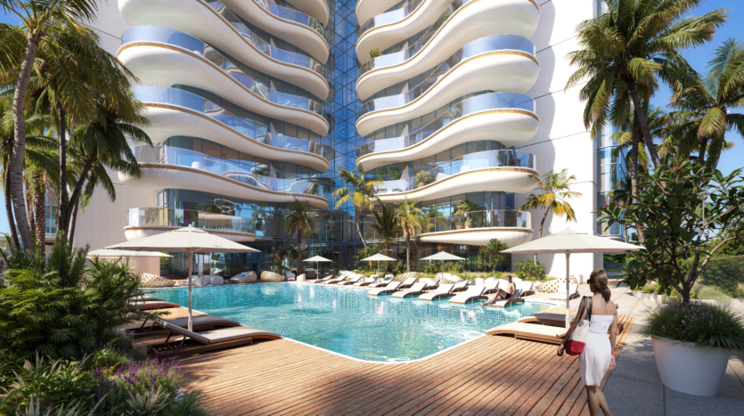 Une femme se tient debout près d'une luxueuse piscine extérieure avec des chaises longues, entourée de palmiers et d'une architecture moderne. Le bâtiment dispose de balcons incurvés et de grandes fenêtres en verre, reflétant un ciel bleu clair.