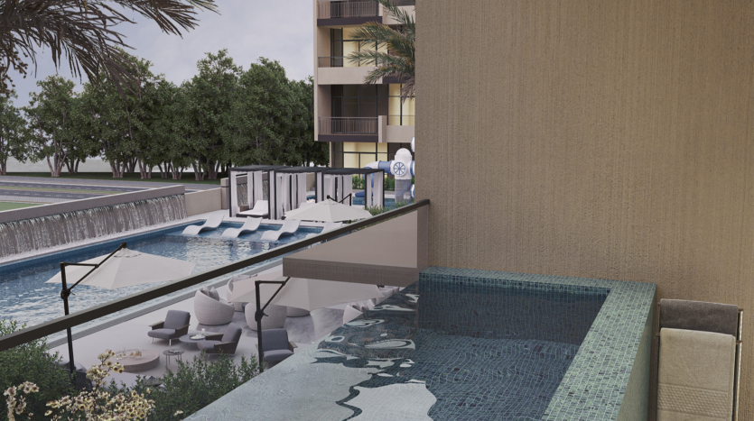 View of a luxurious swimming pool with sun loungers and parasols, surrounded by palm trees and a modern building. In the foreground is a private balcony with a small pool, offering a serene, relaxing atmosphere.
