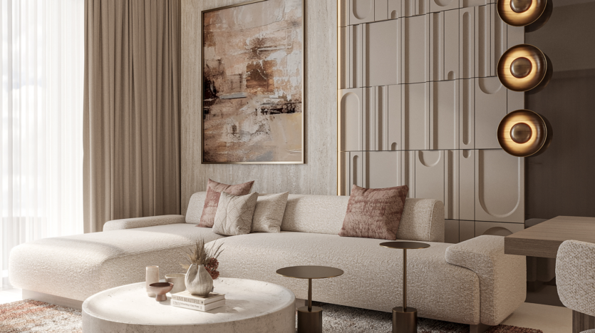 A modern living room with a large beige corner sofa adorned with pink cushions. The room features abstract wall art, geometric wall panels and a round marble coffee table with decorative objects. Warm lighting and a neutral color palette create a welcoming atmosphere.