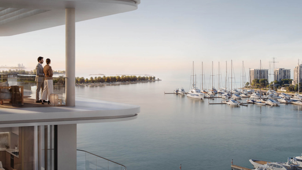 Un couple se tient sur le balcon moderne de Marina Place, surplombant une marina sereine remplie de voiliers au lever du soleil. En arrière-plan, l'horizon de la ville et le rivage bordé d'arbres ajoutent à la vue tranquille.