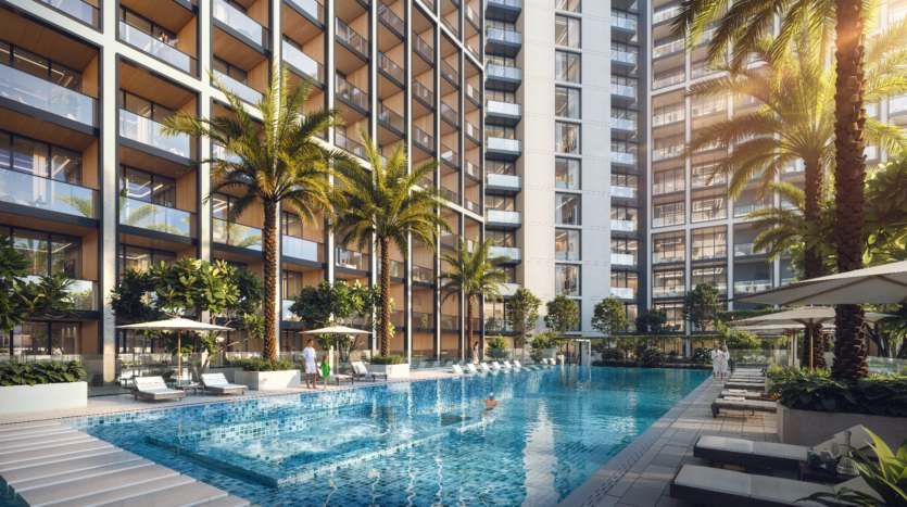 Le complexe d'appartements de luxe de Binghatti dispose d'une grande piscine entourée de palmiers et de chaises longues. Les résidents se détendent sous les parasols dans l'espace extérieur baigné de soleil. Le design contemporain du bâtiment est complété par des balcons privés.