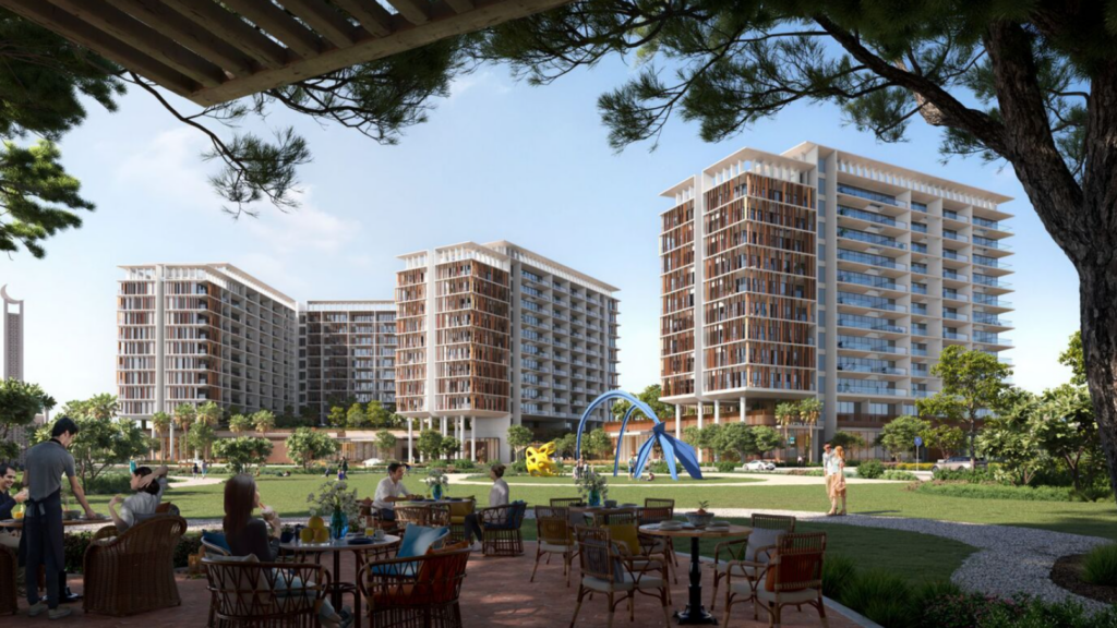 Les gens sont assis sur une terrasse avec des tables au premier plan, profitant d'une vue sur le paysage verdoyant et luxuriant de Parkfive et ses arbres imposants. Des immeubles modernes de grande hauteur et une aire de jeux colorée peuvent être vus en arrière-plan sous un ciel bleu clair.