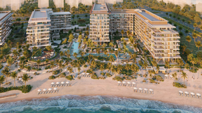 Vue aérienne d'Ellington Cove, un complexe hôtelier de luxe en bord de mer à l'architecture moderne, entouré de palmiers et de jardins paysagers. Le complexe dispose de plusieurs piscines, de chaises longues et d'une plage de sable avec parasols, le tout donnant sur l'océan.