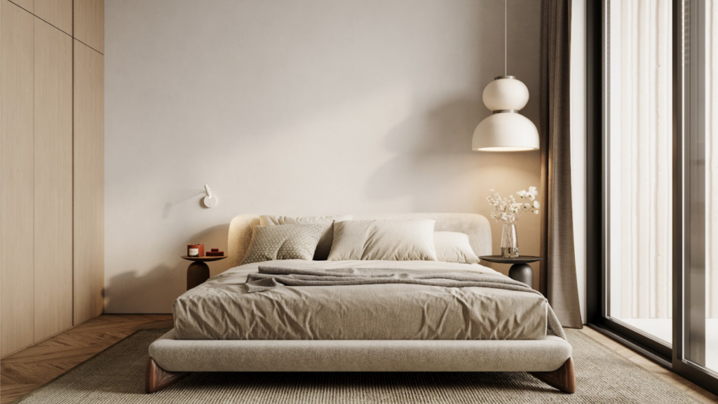 Una camera da letto minimalista ha un letto king size con lenzuola beige, affiancato da due comodini. Una lampada a sospensione e un'applique forniscono l'illuminazione. Accenti in legno chiaro e una finestra a tutta altezza con tenda si aprono su terrazze serene, rafforzando l'atmosfera tranquilla.