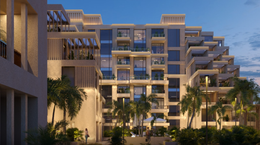 Il moderno edificio a più piani di Arisha è caratterizzato da ampie vetrate e terrazze. Circondato da palme e vegetazione lussureggiante al tramonto, emana un'atmosfera accogliente con la sua illuminazione calda.