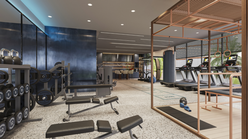A modern gym interior with weight racks, benches, treadmills, exercise bikes and a boxing area. Large windows let in natural light, illuminating the spacious, minimalist design with blue and neutral tones.