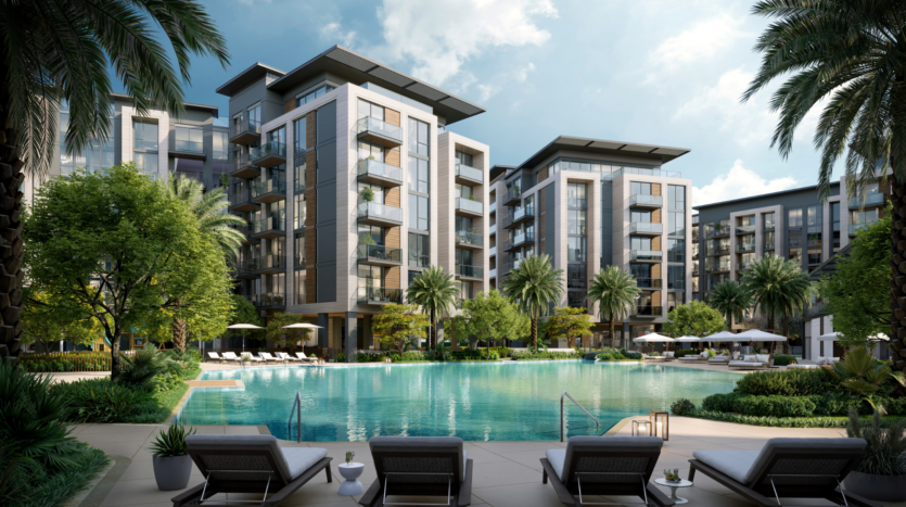 Modern apartment buildings surround a luxurious swimming pool with sun loungers and palm trees. The partly cloudy skies contribute to the relaxing atmosphere of this resort.