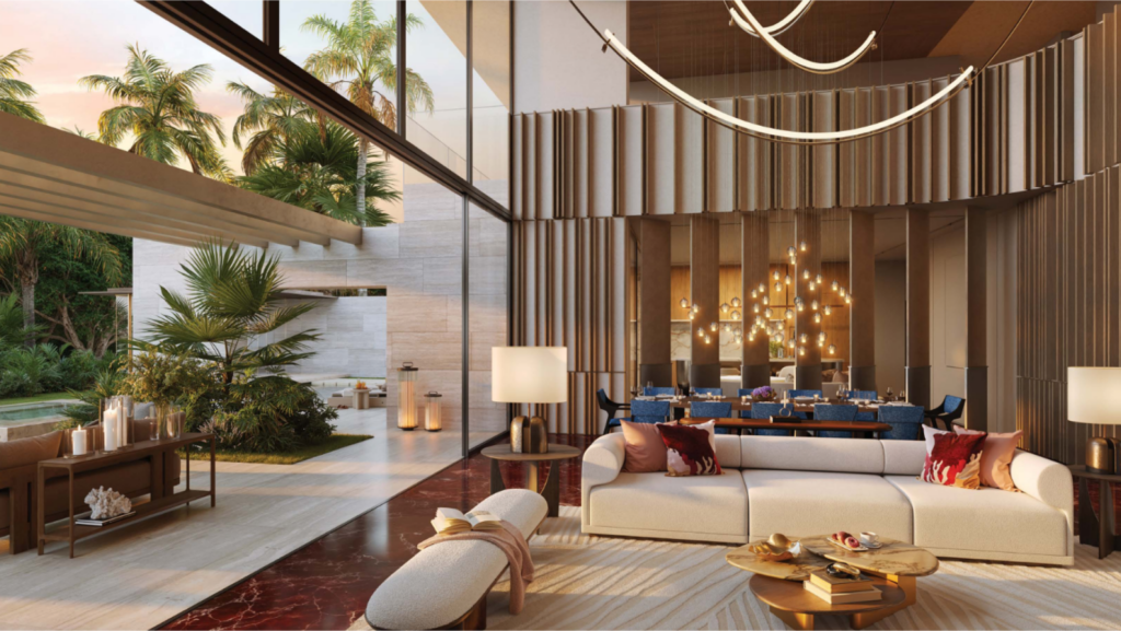 Un salon moderne avec de hauts plafonds et de grandes fenêtres s'ouvre sur un patio avec des palmiers, capturant l'essence de l'élégance Bo Monde. L'espace comprend un élégant canapé beige, un sol en marbre rouge, des accents en bois et une table à manger avec un lustre, créant une ambiance luxueuse et ouverte.