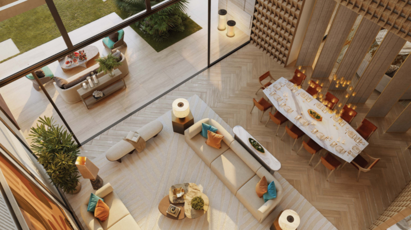 Un espace de vie spacieux et moderne vu d'en haut, comprenant deux coins salon, une table à manger et de grandes fenêtres donnant sur un jardin. Bénéficiant du style caractéristique de Bo Monde, la pièce présente une palette de couleurs chaudes avec un sol beige, des coussins orange et bleu sarcelle et des plantes décoratives.